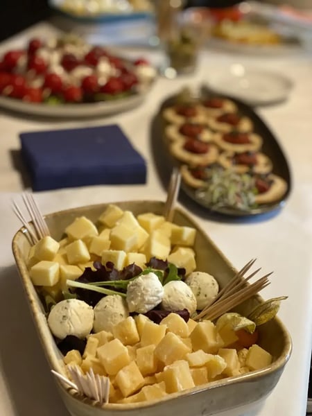 Cheese platter with cubed mild and aged cheeses, garnished with herbed cream cheese balls.