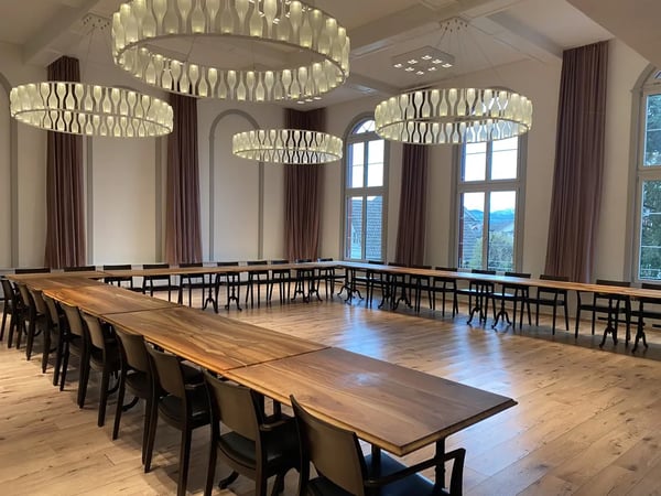 Conference in the Löwen Hall with tables arranged in a U-shape. Presentation or meeting.
