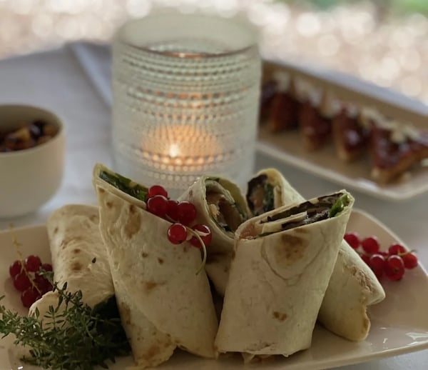 Vegetable wraps garnished with fresh red currants and herbs.