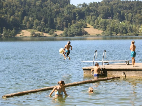 Fun at the Türlersee swimming area with diving board and raft.
