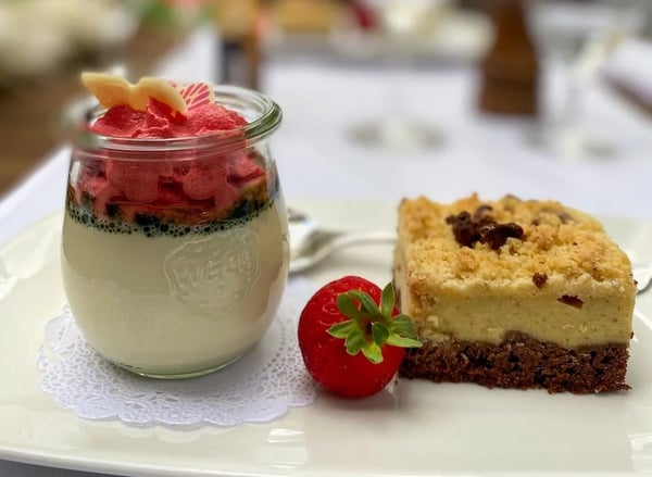 Dessert duo: Refreshing raspberry sorbet on vanilla mousse in preserving jar and crumble cake, garnished with fresh strawberry.