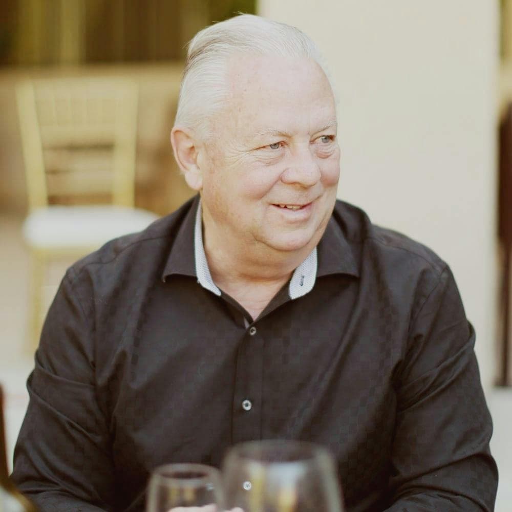 Professional headshot of a man in a dark suit (team portrait).