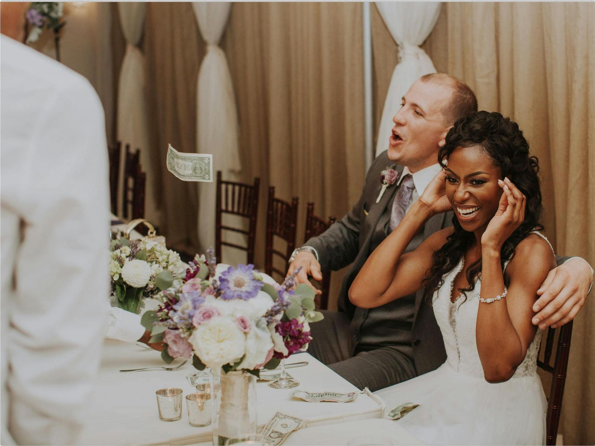 Outdoor ceremony or reception on lawn with white chairs and floral arch.
