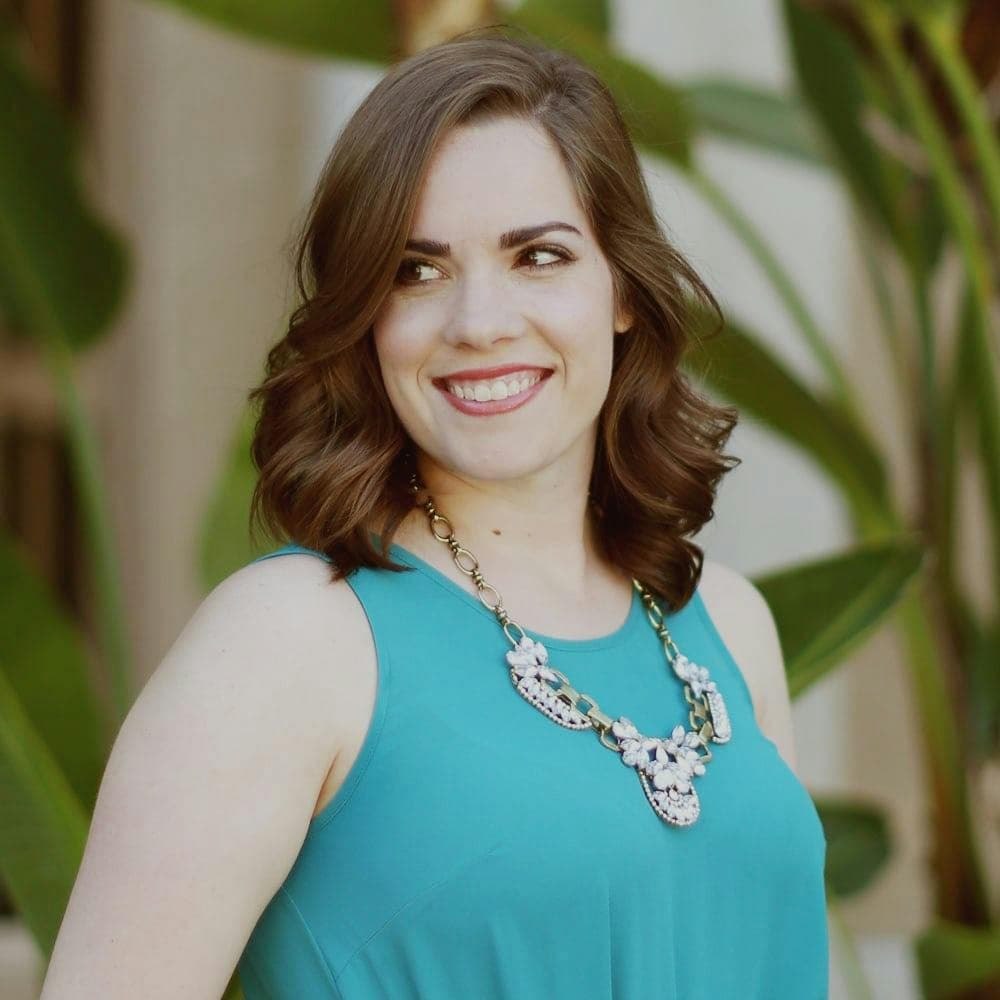 Headshot of a woman with curly hair in business attire.