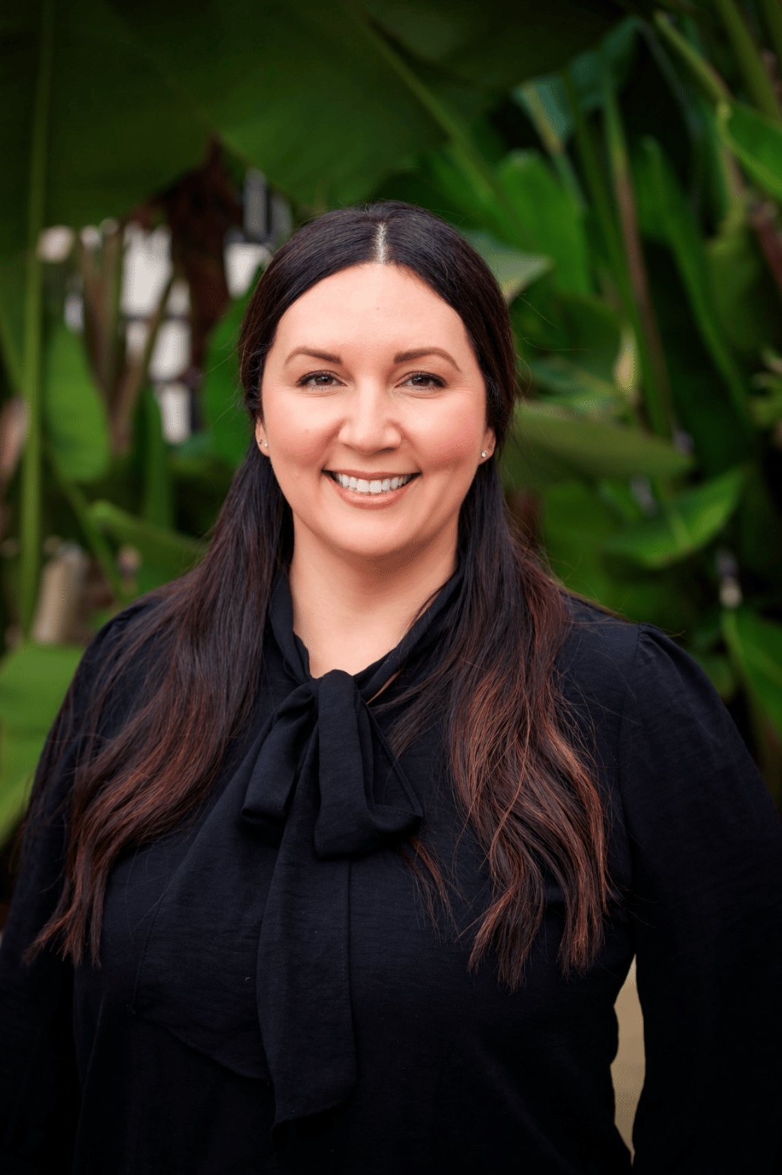 Portrait of a woman at a reception desk with Grand logo wall.