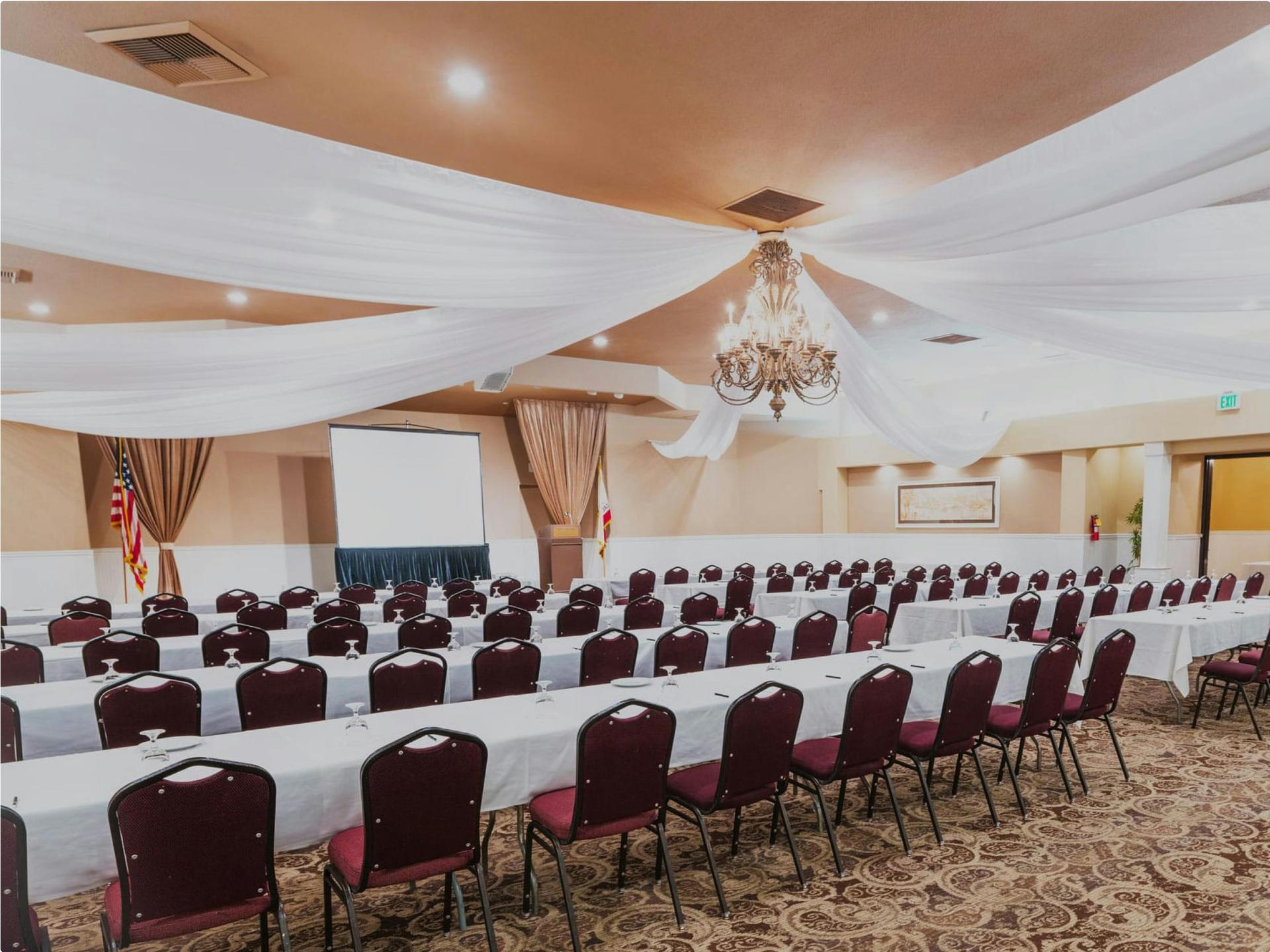 Conference or seminar room with screen and classroom rows.
