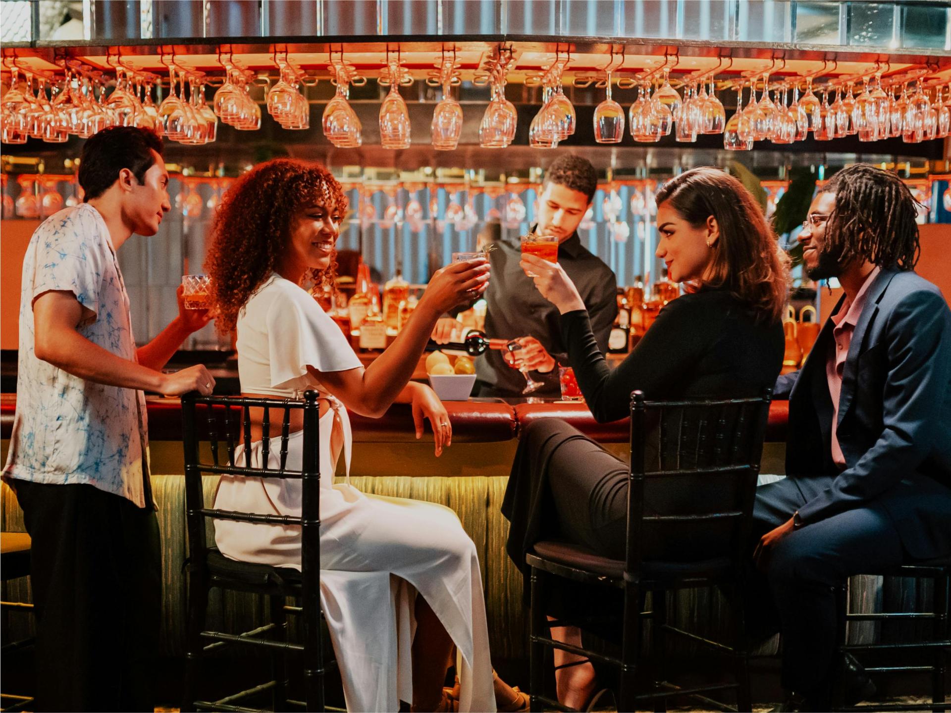 Ballroom with cake table, dessert spread, and pink lighting.