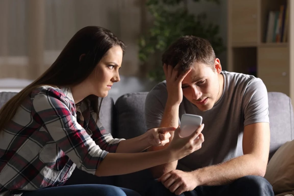 žena apeluje na muže, aby jí vysvětlil jednu položku v telefonu