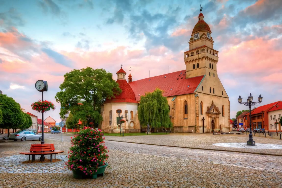 Kostel sv. Alžběty ve městě Skalica při západu Slunce. Přilehlé náměstí je liduprázdné.