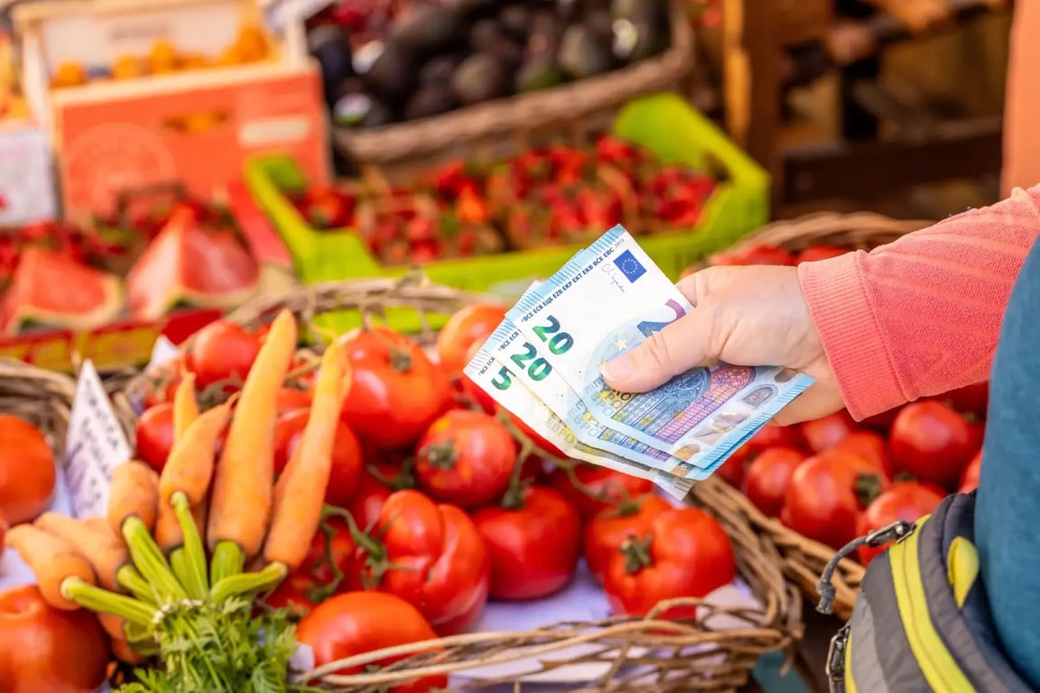 Žena drží eurové bankovky v obchodě 