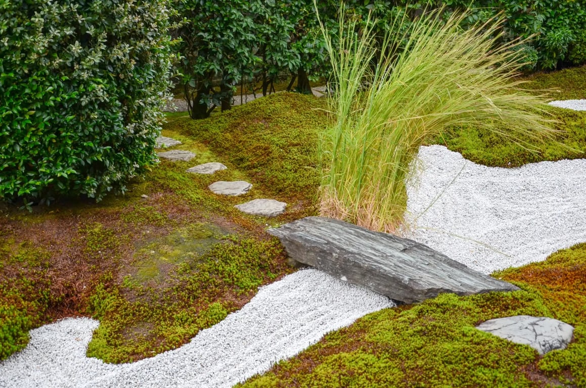 Suchý potok na zahradě s mostem a pískem.