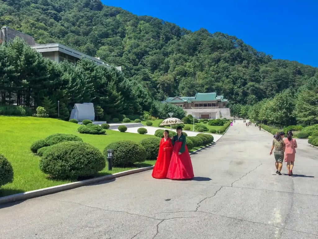 Severní Korea, turistická oblast, v popředí ženy v tradičním oděvu.