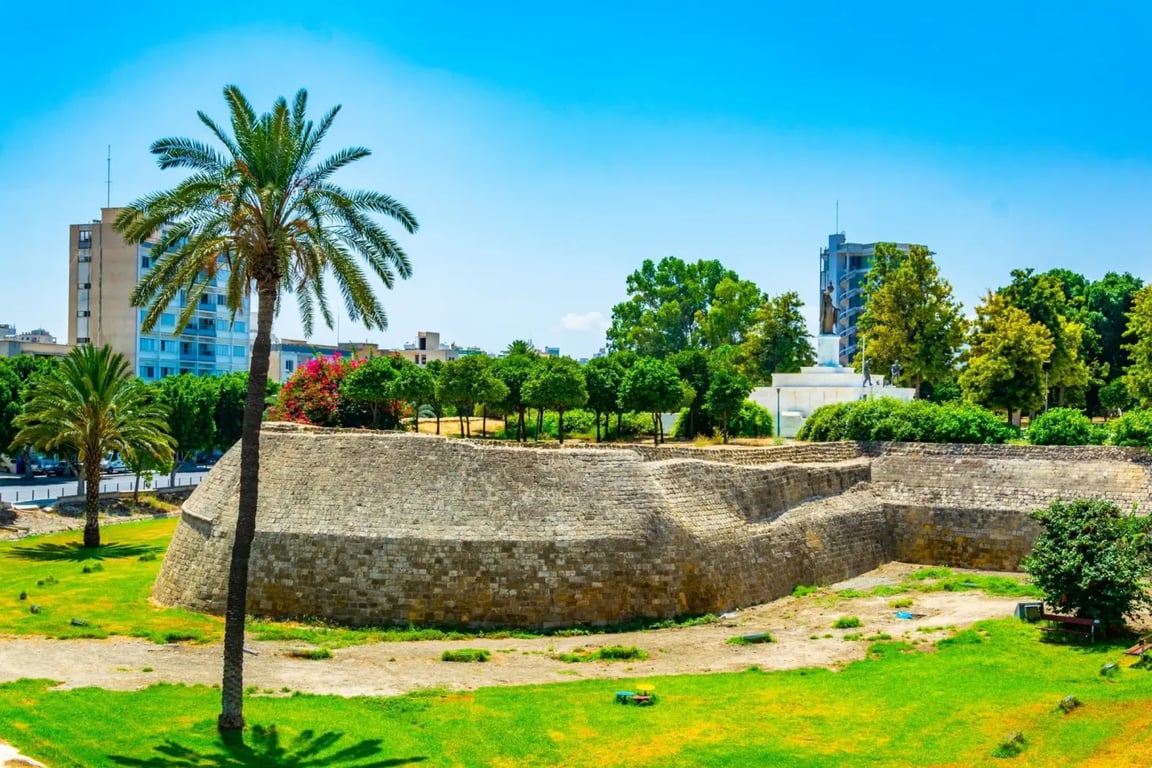 Benátské opevnění ve městě Nikósie. Je krásný den, modrá obloha bez mráčků. V okolí jsou vidět zelené stromy.