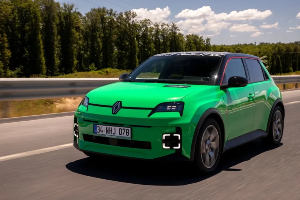 Zelený hatchback Renault 5 jede po silnici za slunečného dne
