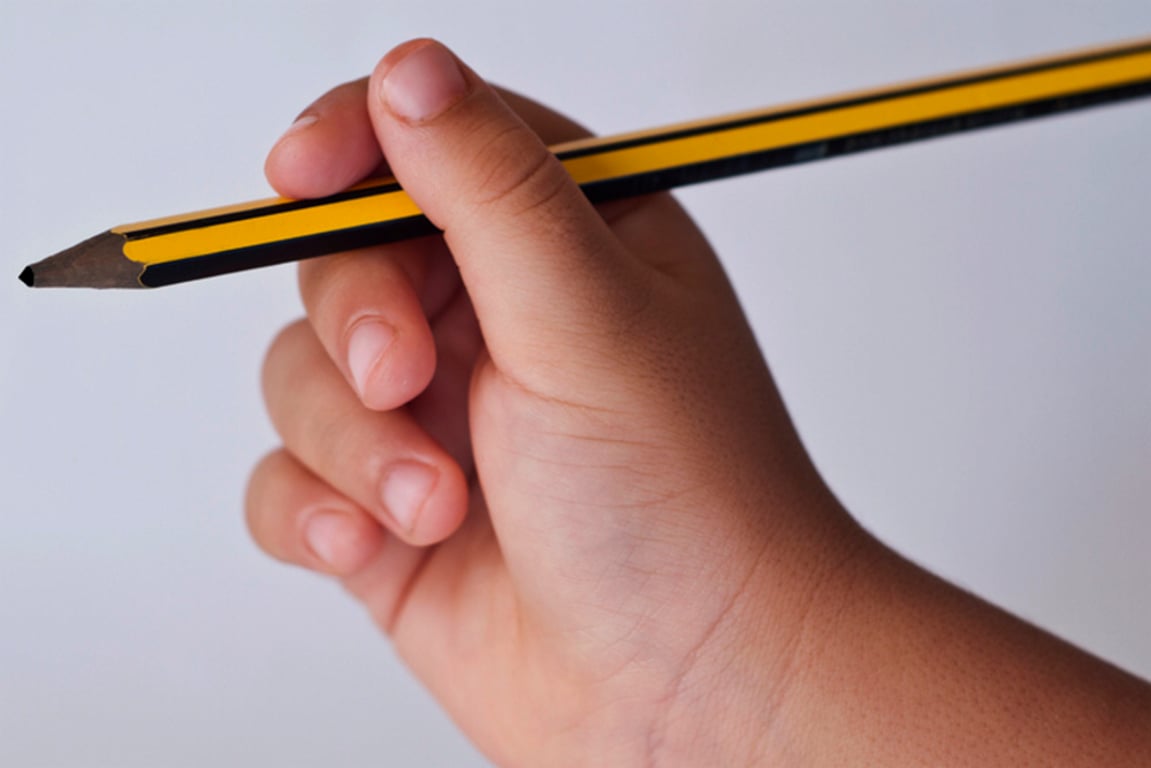 Dětská ruka drží tužku