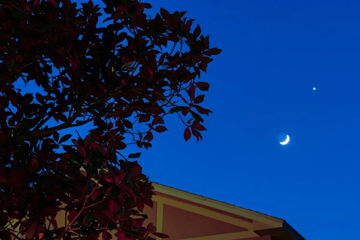 Noční obloha se zářícím měsícem a Venuší