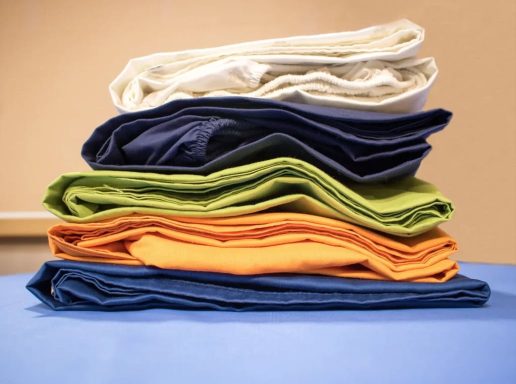 poskládaná natahovací prostěradla různých barev