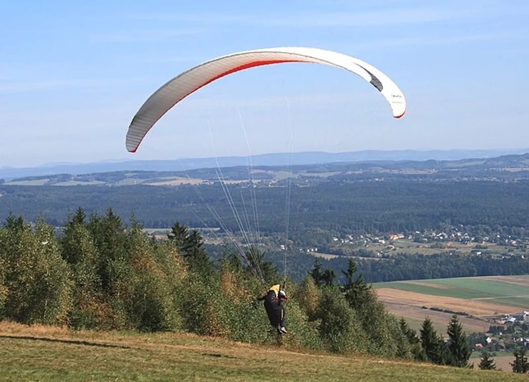 Na kopci Zvičina se chystá k letu paraglider