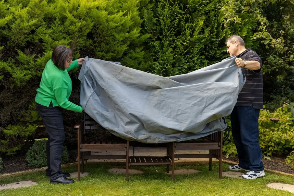 Starší pár zakrývá zahradní nábytek
