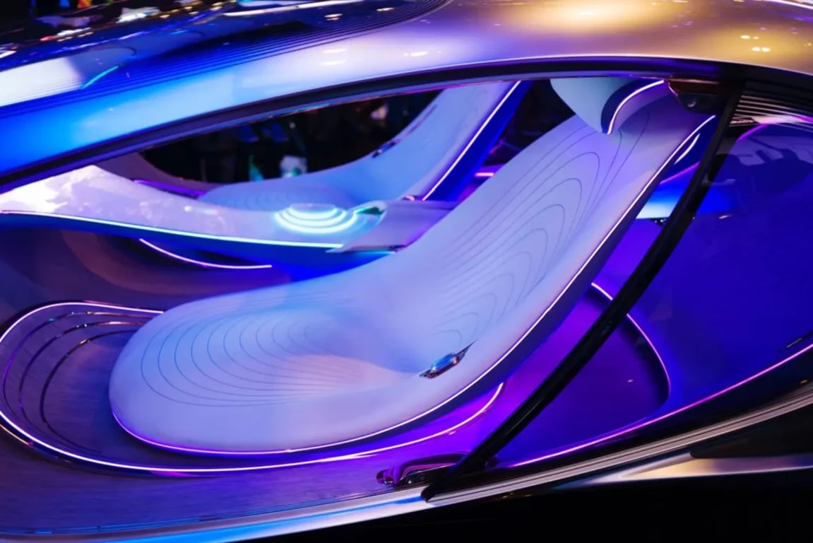Detail futuristického interiéru vozu Mercedes-Benz VISION AVTR s plynulými tvary sedadel, fialovým a modrým ambientním osvětlením a minimalistickým designem bez volantu