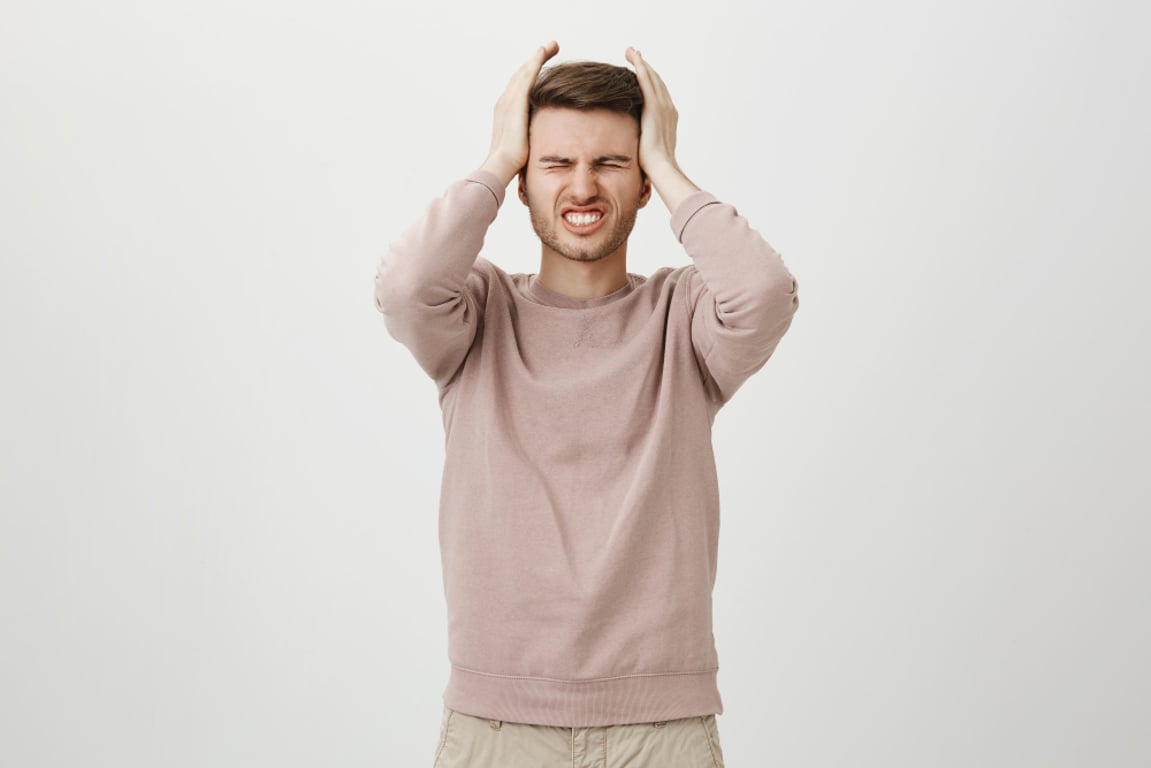 Muž s bolestí hlavy držící se v agónii za hlavu