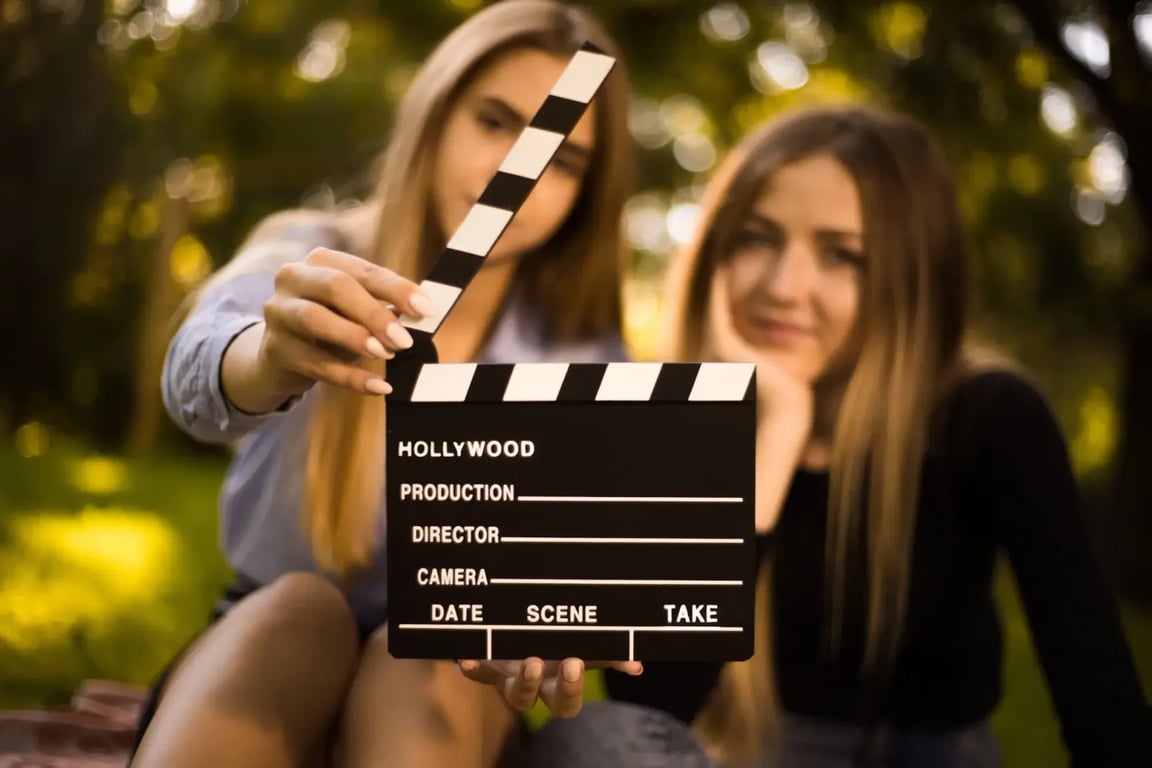 dívka drží v ruce filmovou klapku