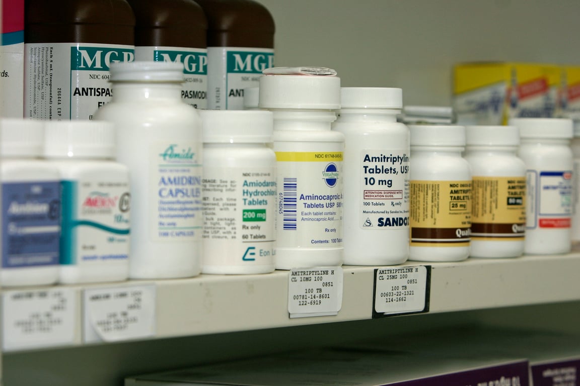 Pharmacy shelf stocked with prescription bottles