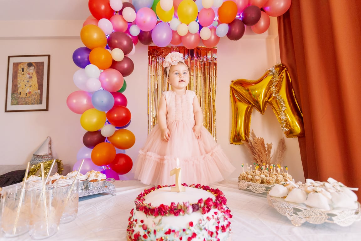 Child standing on table surrounded by party decorations
