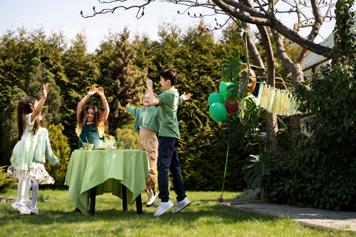 Children playing at a jungle themed birthday party, they are all dressed in green.