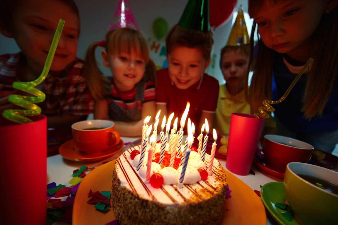 Children looking at a cake with candles