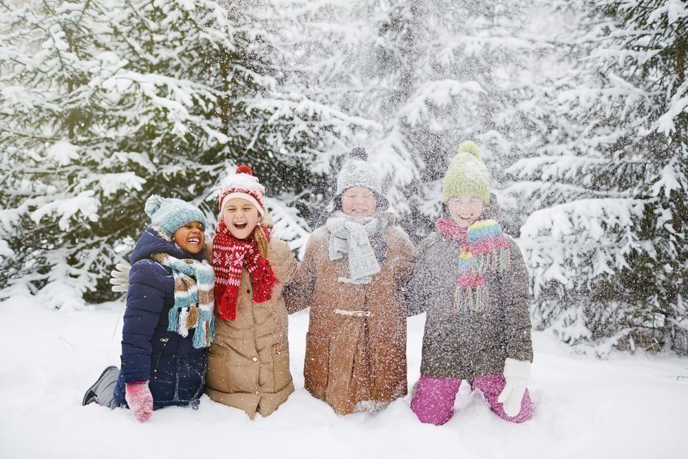 Kids building snowmen and forts during a snow day birthday party.