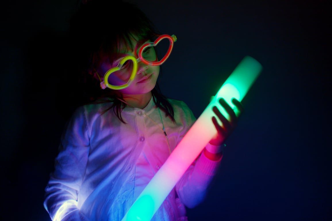 Child holding neon sign at glow party event