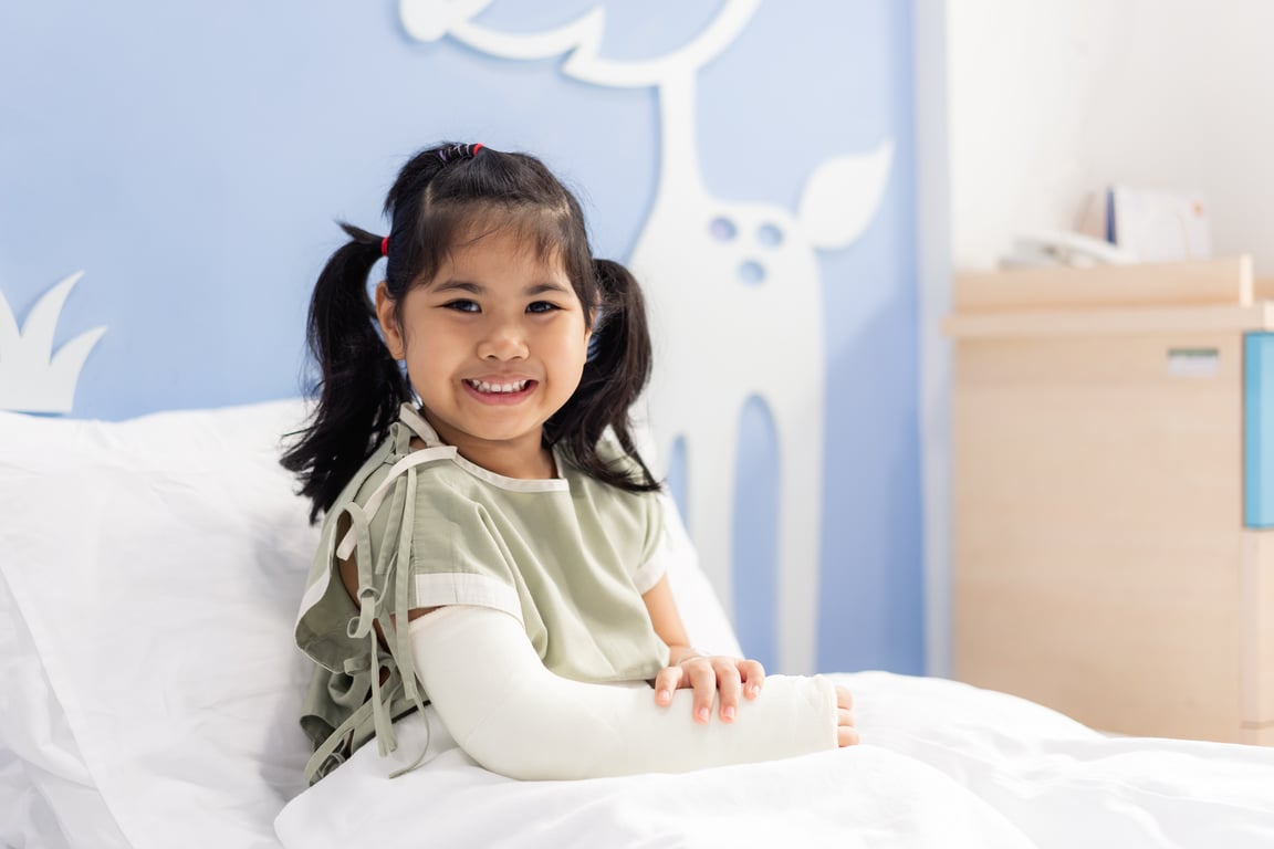 Child smiling in a hospital bed.