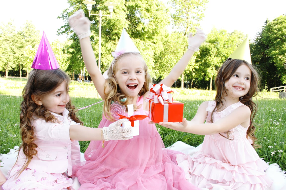 Children smiling while sitting in the grass
