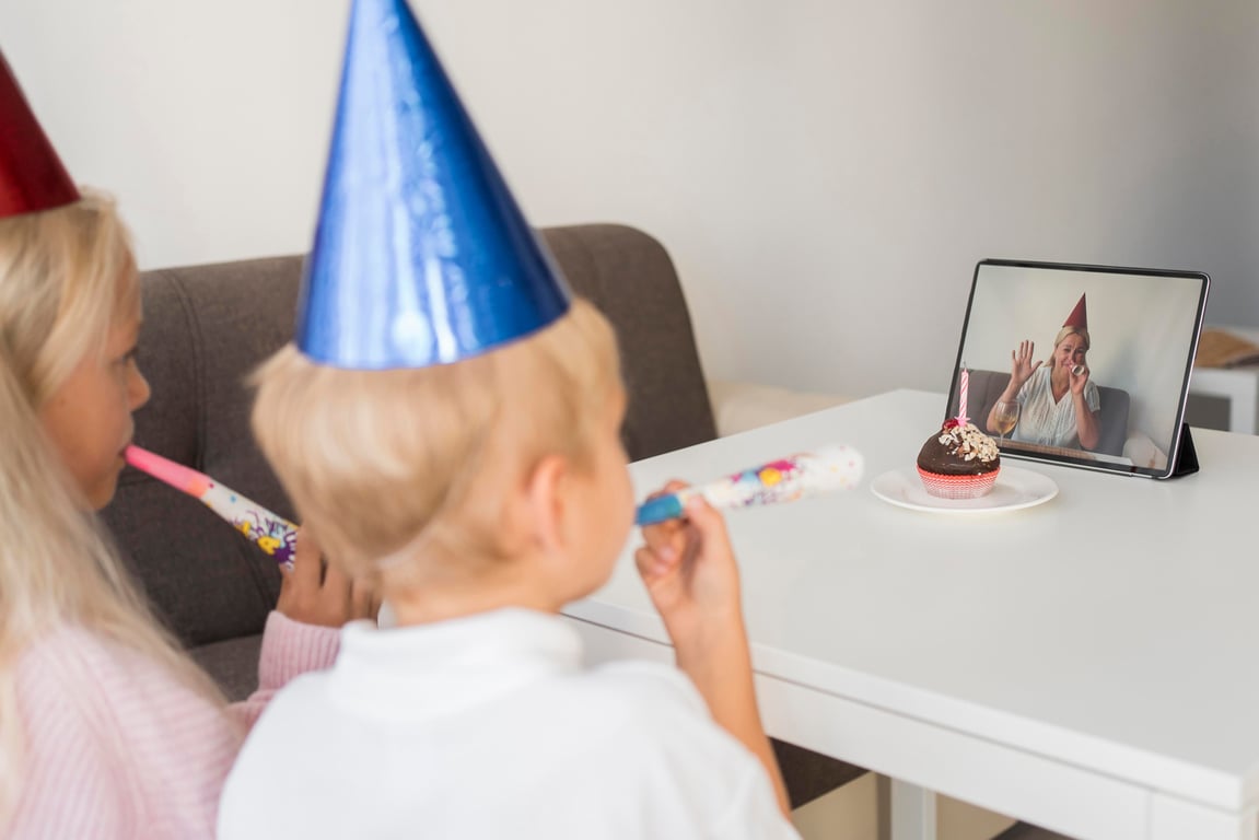 Children celebrating a virtual birthday with their mother on a tablet.