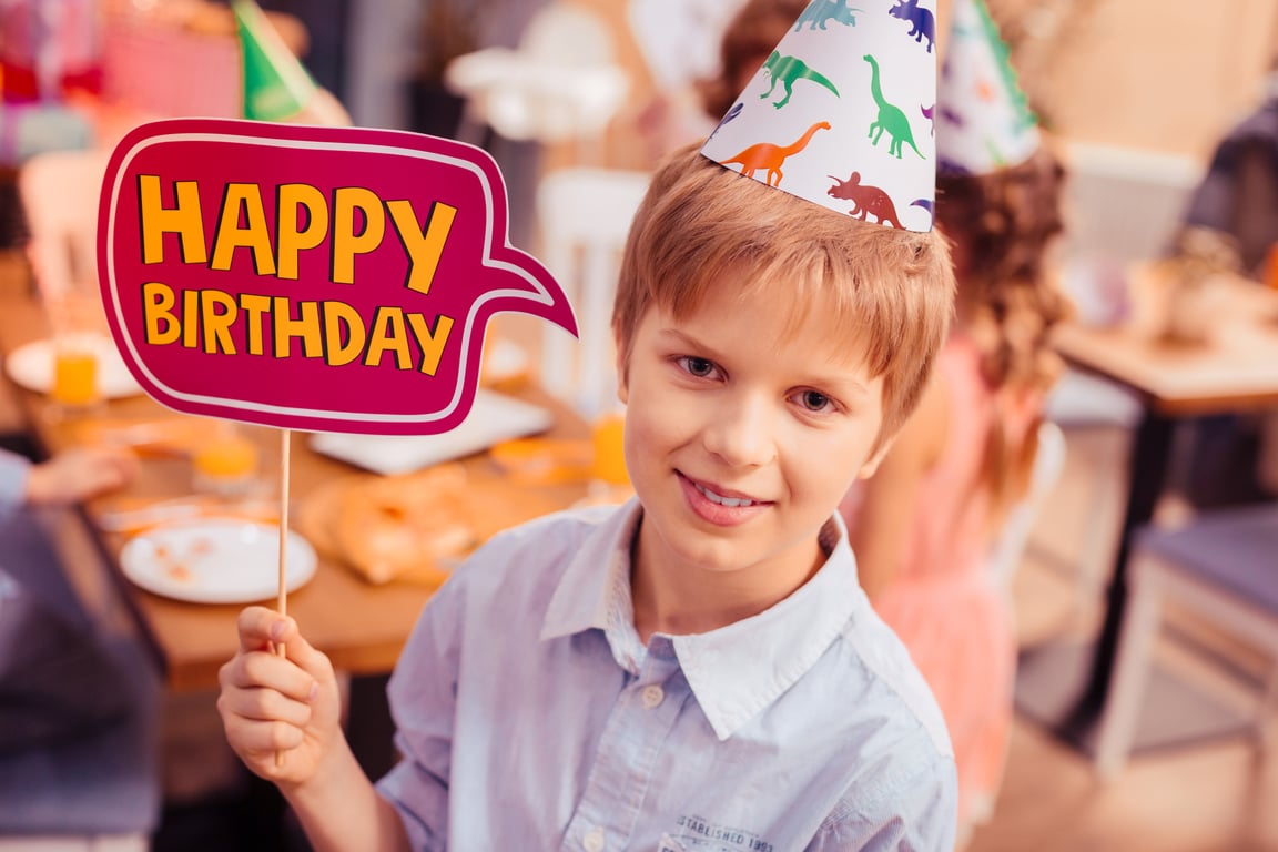 Child holding Happy Birthday sign.