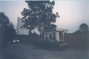 Cars driving up to the 411 ticket booth at sunset.