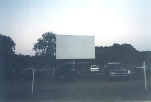 Cars in front of the 411 screen at sunset.