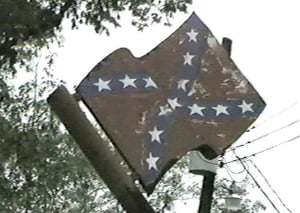 The last, defiant Rebel Flag (a metal one) stands atop the ticket booth the day the drive-in was torn down.