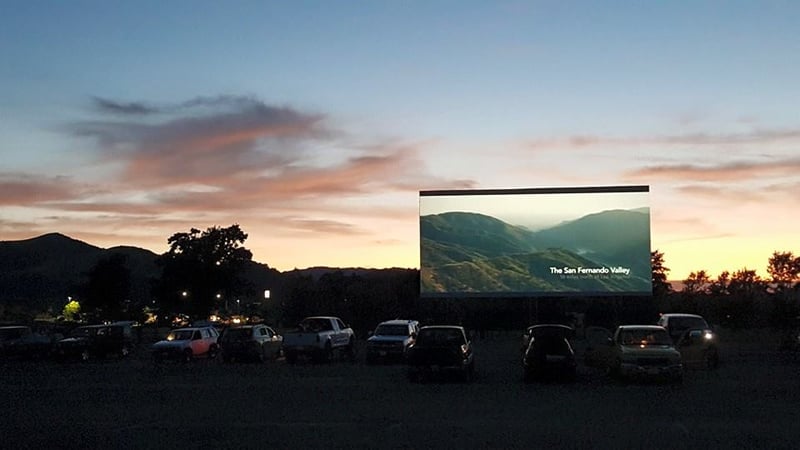 A beautiful digital picture on the screen and a gorgeous sunset in the background.