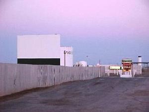 driveway and side fence. the ticket booth and a few nearby industrial buildings can be seen in the distance.