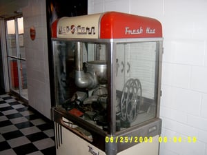 Old popcorn machine in the concession stand, which has a film reel and some old speakers inside.