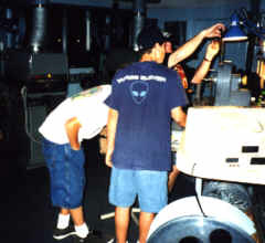 Larry the Projectionist shows the photographer's sons Paul and Ryan how to repair a piece of film.
