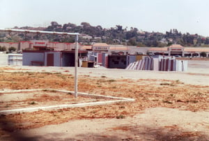 Disorganised looking projection and concession buildings with frame of children`s swings visible