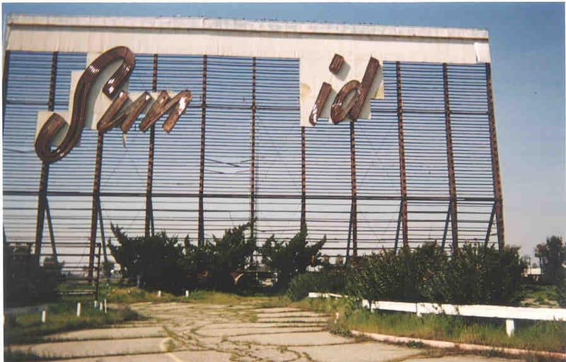 Reamins of screen tower. Remainder of neon sign is in the bushes at the base of the tower.