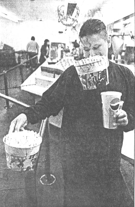 Caption: Ernesto Diaz, 15, has his hands - and mouth - full of soft drinks and popcorn.  Says the Valley's manager, Jud Burks, "What little we make comes off the snack bar on the weekends."