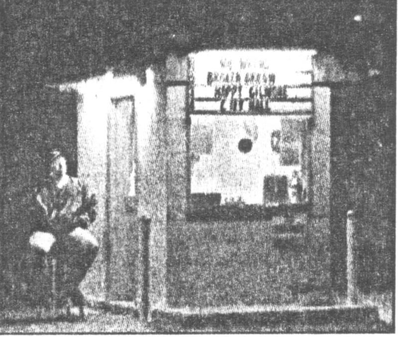 Caption: Jim Corcoran waits for late arrivals at the Valley Drive-in's ticket booth.  ["Happy Gilmore" and "City Hall" were among the films playing at the time.]