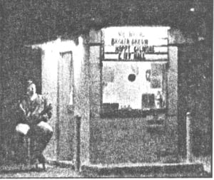Caption: Jim Corcoran waits for late arrivals at the Valley Drive-in's ticket booth.  ["Happy Gilmore" and "City Hall" were among the films playing at the time.]