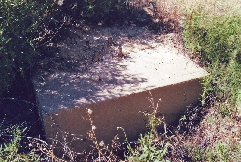 This concrete screen tower foundation I found outside the sheet metal fence behind which scrap cars are stored