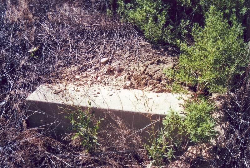 Another half buried concrete screen tower foundation